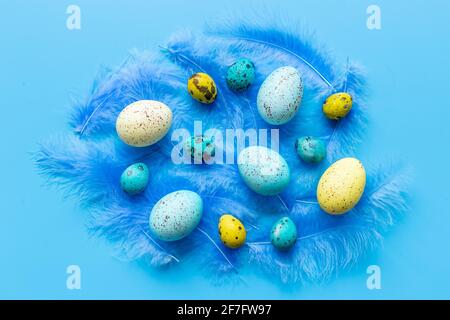 Layout von bunten Ostereiern und Vogelfedern, Draufsicht Stockfoto