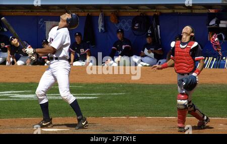 Sydney Olympics Games September 2000 Baseballspiel, USA gegen Japan, Marcus Jenson trifft einen Skipper und Fänger Fumihiro Suzuki macht sich bereit, den Ball zu fangen Stockfoto