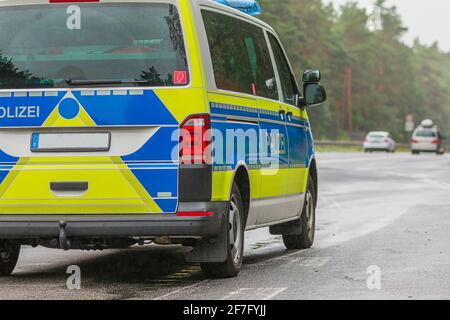 Seitenansicht des deutschen Polizeiwagens. Beifahrerseite des Fahrzeugs auf der Autobahn bei Regenwetter mit der Aufschrift Police auf der Karosserie in blau und y Stockfoto