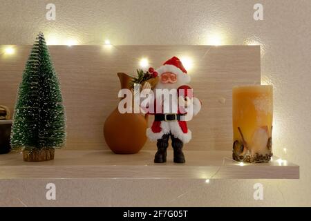Der Weihnachtsmann und ein kleiner Weihnachtsbaum auf einem hölzernen Baum Regal Stockfoto