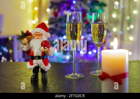 Der Weihnachtsmann und zwei Gläser Champagner auf dem schwarzen Tabelle Stockfoto
