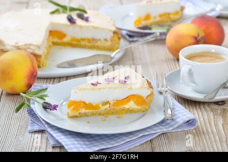 Köstliche Pfirsichtarte mit Lavendelhonig und süßer Baiser Serviert auf einem Holztisch mit einer Tasse Kaffee creme Stockfoto