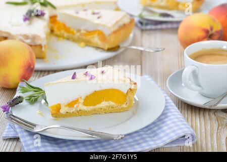 Köstliche Pfirsichtarte mit Lavendelhonig und süßer Baiser Serviert auf einem Holztisch mit einer Tasse Kaffee creme Stockfoto