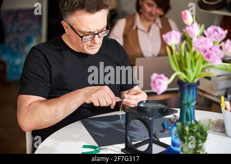 Zwei konzentrierte, reife kaukasische Kreative, die zusammen arbeiten Stockfoto