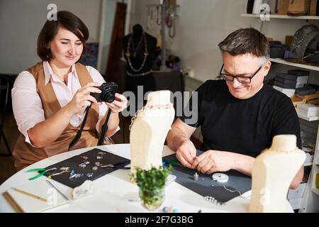 Erfreut fotografierte die Kunsthandwerkerin ihren neuen Anhänger auf der Büste des Displays Stockfoto