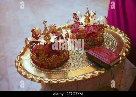 Goldene Kronen für Hochzeit und Bibel in orthodoxer Kirche Nahaufnahme Stockfoto