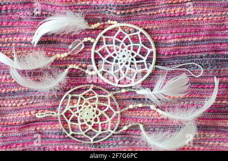 Traumfänger mit Federn auf textilen Hintergrund. Ethnisches Design, Boho-Stil, Tribal-Symbol. Stockfoto