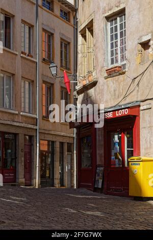 LYON, FRANKREICH, 6. April 2021 : Place de la Trinité. Der Platz, vollständig gepflastert und von alten Gebäuden (18. Jahrhundert) umgeben, ist eine Kreuzung von kleinen stre Stockfoto