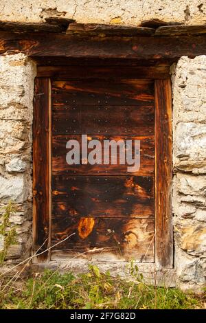 Alte Holztür, Teil einer der alten Hütten und Gebäude, die auf den Weiden des Gistain-Tals, der aragonesischen Pyrenäen, Huesca, liegen Stockfoto