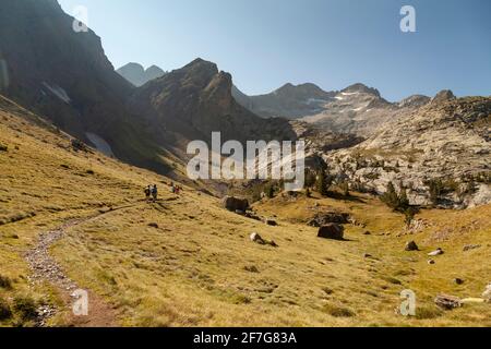 Landschaftsfotografie der einsamen Berge im Sommer, unter einem riesigen blauen Himmel, während eine Gruppe von Wanderern in der Ferne zu Fuß, Aragonische Pyrenäen, Hu Stockfoto