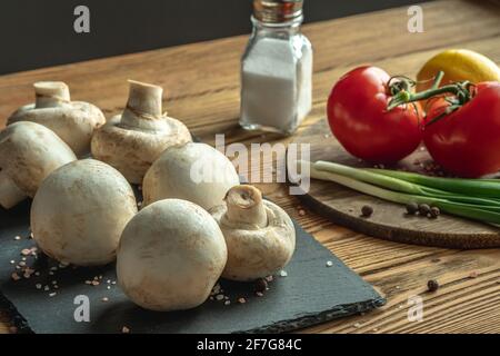 Pilze, Gemüse und Gewürze auf einem Holztisch. Konzept der Zutaten für das Kochen ein leckeres Essen. Stockfoto