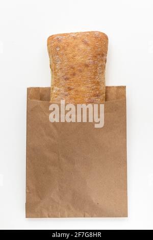 Frisch gebackenes italienisches Ciabatta-Brot aus Weizenmehl in Verpackung auf weißem Hintergrund. Draufsicht flach liegend Stockfoto