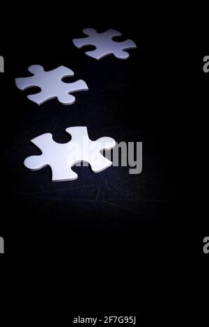 Weiße Details des Puzzles auf schwarzem Hintergrund. Mit Kopierbereich Stockfoto