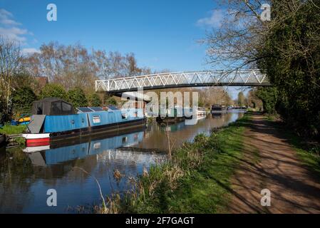 Kennet und Avon Canal, Aldermaston Wharf, Aldermaston Wharf, England, Großbritannien. 2021. Hausboote säumen den Kennet- und Avon-Kanal unter einer Fußgängerbrücke auf der Ken Stockfoto
