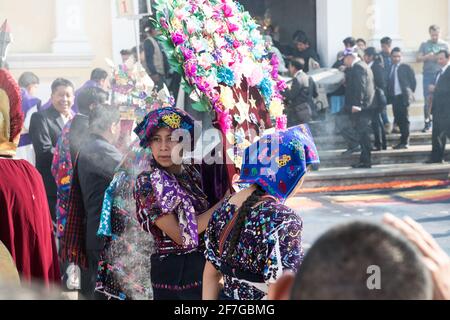 Indigene guatemaltekische Frauen in traditioneller Kleidung verbrennen Weihrauch während der Semana Santa Prozession in Antigua, einem feierlichen Ritual voller Geschichte. Stockfoto