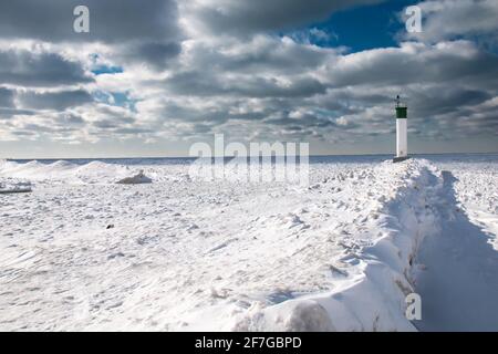 Grand Bend, Ontario, Kanada - am Rande des Grand Bend Pier blickt der Leuchtturm auf einen dicken Eisteppich inmitten eines polaren Wirbels. Stockfoto