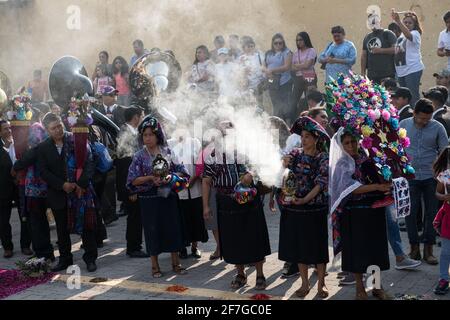 Indigene guatemaltekische Frauen in traditioneller Kleidung verbrennen Weihrauch während der Semana Santa Prozession in Antigua, einem feierlichen Ritual voller Geschichte. Stockfoto