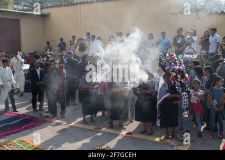 Indigene guatemaltekische Frauen in traditioneller Kleidung verbrennen Weihrauch während der Semana Santa Prozession in Antigua, einem feierlichen Ritual voller Geschichte. Stockfoto