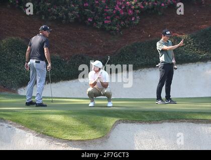 Augusta, USA. April 2021. Phil Mickelson, von links, sieht zu, wie Paul Casey darauf reagiert, dass er gerade seinen Birdie-Putt verpasst hat, während Viktor Hovland seinen Putt am Dienstag, dem 6. April 2021, während der Übungsrunde für die Masters im Augusta National Golf Club in Augusta auf dem 12. Grün auslegt. (Foto von Curtis Compton/Atlanta Journal-Constitution/TNS/Sipa USA) Quelle: SIPA USA/Alamy Live News Stockfoto