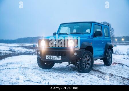 Moskau, Russland - 24. Januar 2020: Neuer Suzuki Jimny Mini-SUV auf Winterstraße am Abend. Japanische Suzuki SUV mit Scheinwerfer an. Keine Menschen. Stockfoto