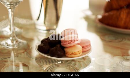 Makronen auf einem Glastisch. Zum Frühstück gab es Süßigkeiten. Sonniges Foto Stockfoto