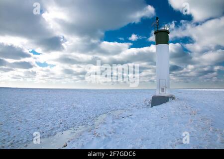 Grand Bend, Ontario, Kanada - am Rande des Grand Bend Pier blickt der Leuchtturm auf einen dicken Eisteppich inmitten eines polaren, wirbelkalten Schnapps. Stockfoto