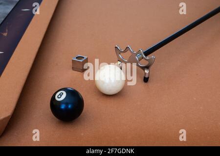 Draufsicht auf eine Billardbrücke, weiße Kugel, acht Kugeln und Queue-Kreide auf einem Billardtisch aus Goldfilz, Toronto, Ontario, Kanada. Stockfoto