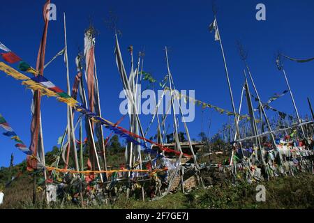 Buddhistische Gebetsfahnen wehen bunt im Wind. Im Königreich Bhutan im Himalaya, Asien, als Fahnen und stehende Fahnen mit Bitten und Beten Stockfoto