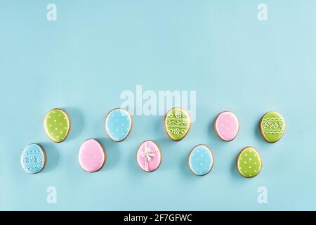 Bemalte Lebkucheneier mit bunten Glasur isoliert auf hellblauem Hintergrund bedeckt. Süßigkeiten für Ostern feiern. Stockfoto