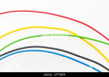Farbige Drähte, Kupferdrähte mit farbigem Kunststoff für elektrische und technologische Verbindungen. Kabel auf weißem Hintergrund. Grundfarben. Stockfoto