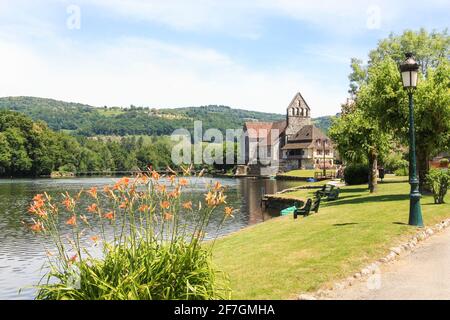 Beaulieu sur Dordogne und die Kapelle der Büßer an der Dordogne mit einem Wehr über dem Fluss im Hintergrund, Correze, Limousin, Frankreich Stockfoto