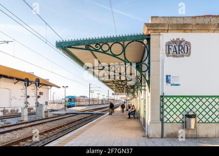 Faro, Portugal - 24. März 2021: Ein paar Pendler warten auf den Bahnhof in Faro, Algarve, Portugal