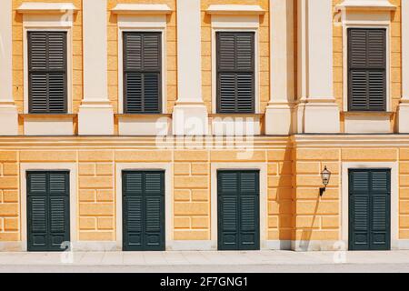 Schließen Sie die Tür- und Fensterläden an der gelben Fassade Stockfoto