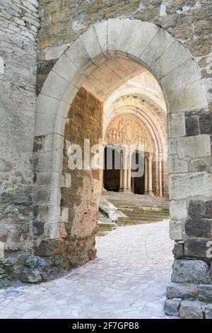 Blick durch den Innenhofbogen des Eingangs zur Kirche St. Pierre, Carennac, Lot, Frankreich mit ihrem 12. Jahrhundert Tympanon des Apost;es und Christi Stockfoto