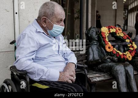 Jerusalem, Israel. April 2021. Ein älterer Mann sitzt neben einer von Dr. Martin Kieselstein geschaffenen Statue auf der Bank, die dem Gedenken aller Großmütter und Großväter unter den sechs Millionen jüdischen Opfern des Holocaust am Vorabend des Gedenktages der Märtyrer und Helden des Holocaust, Yom HaShoah, gewidmet ist. Kredit: Nir Alon/Alamy Live Nachrichten Stockfoto