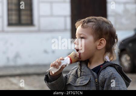 Junge mit Eiskegel auf der Straße Stockfoto