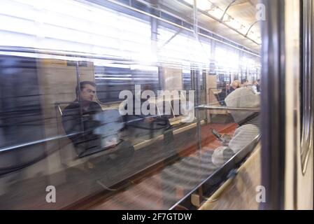 Moskau. Russland. Herbst 2019. Die Leute fahren in einem U-Bahn-Auto. Reflexion in einem U-Bahn-Auto. Stockfoto