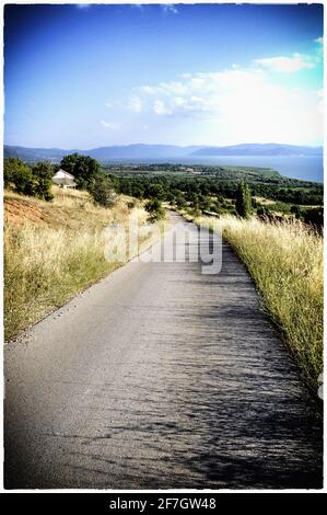 Asphaltierte Straße, die den Berg hinunter führt Stockfoto