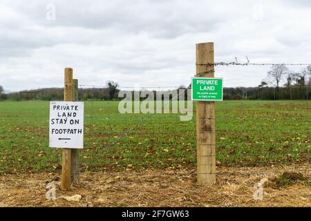 „Privatland“, „Stay on Footpath“-Schilder entlang eines öffentlichen Wegs, das durch Ackerland führt. Oxfordshire, Großbritannien Stockfoto