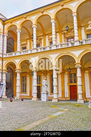 TURIN, ITALIEN - 9. Mai 2012: Der Innenhof des historischen Palazzo degli Stemmi (Palast) mit Arkade, komplexen Säulen, Stuckdekorationen und Minerva Statu Stockfoto