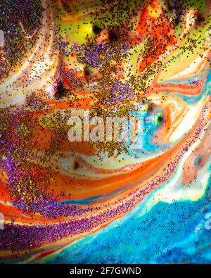 Mehrfarbiger Acryl-Hintergrund mit Locken bestreut mit lila und Gold funkelt. Moderne Kreativität. Eine bunte Avantgarde-Malerei mit reichen Stockfoto