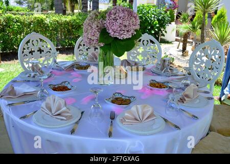 Hochzeitstisch und Blumenstrauß in der Mitte mit Tischeinstellungen Stockfoto