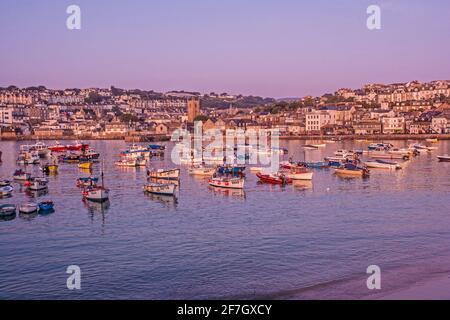 Ives Harbour, während das frühe Morgenlicht ein warmes Licht ausstrahlt Glow over the Waterfront in St Ives, Cornwall, Großbritannien Stockfoto