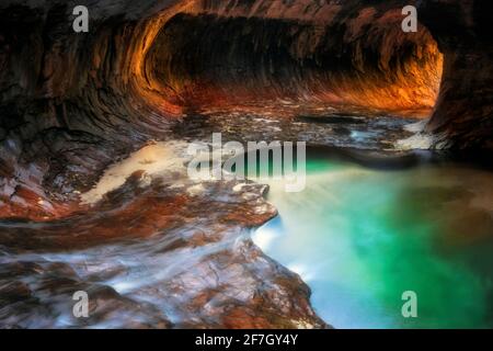 Reflektierendes Licht beleuchtet die Labyrinth-Schlitzschluchtwände der Subway mit ihren smaragdgrünen Pools im Zion National Park. Stockfoto