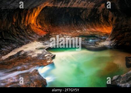 Reflektierendes Licht beleuchtet die Labyrinth-Schlitzschluchtwände der Subway mit ihren smaragdgrünen Pools im Zion National Park. Stockfoto