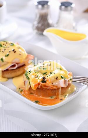 Frühstück. Best Eggs Benedict - gebratenes englisches Brötchen, Schinken, pochierte Eier und köstliche Hollandaise Butter Sauce Stockfoto