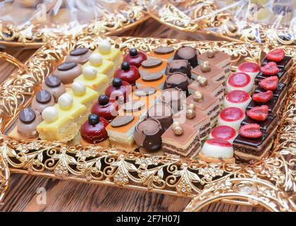 Bunte Präsentation von Gebäck mit Früchten gekrönt (Geringe Schärfentiefe) Stockfoto