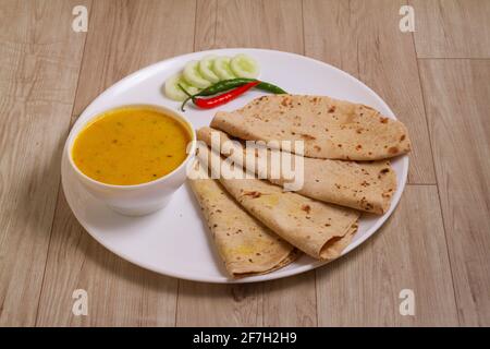 Indische Küche Kadhi chapati - Vegetarische Curry aus Buttermilch und Kichererbsenmehl. Serviert in einer Schüssel oder Karahi auf Holzhintergrund, selektive f Stockfoto