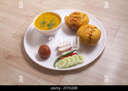 Rajasthani traditionelle Küche Dal Baati auch bekannt als Dal Bati oder Daal Baati Churma auf Holzhintergrund. Es ist beliebt in Rajasthan, Uttar Pradesh an Stockfoto