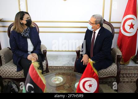 Der neue Außenminister Libyens, Najla al-Manqoush (C), trifft sich auf dem Flughafen Tunis Carthage mit dem tunesischen Außenminister Othman Jerandi (L). Der neue Außenminister Libyens, Najla al-Manqoush, reiste heute nach Tunesien, um die Nachbarländer seit 2012 zum ersten Mal zu besuchen, wie sein Büro mitteilte, um die neue von den Vereinten Nationen unterstützte Regierung Libyens anzukurbeln. Stockfoto